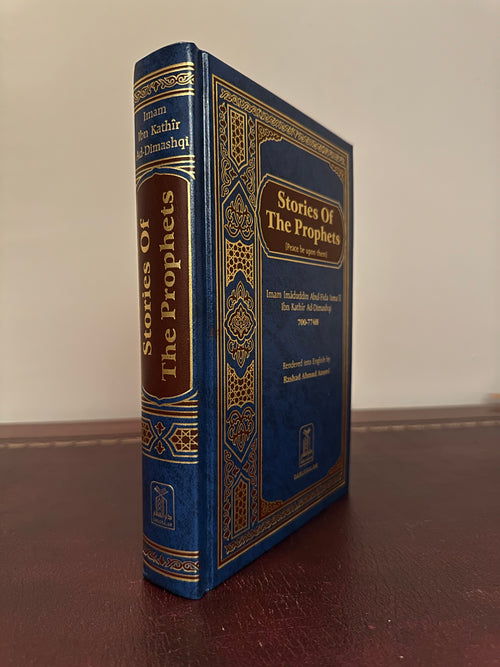 Spine and front cover of the blue Darussalam Stories of the Prophets hardback standing on a brown leather desk.
